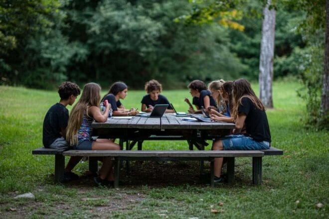 Image d'illustration. Adolescents discutant technologie à table pique nique