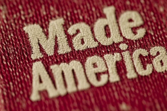 This image is an artistic portrayal featuring iconic American symbols encircling the "Made in America" phrase, all set on a vibrant red canvas.