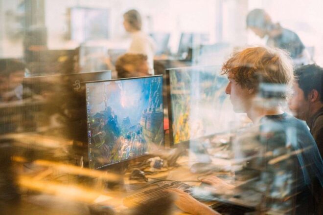 Concepteurs de jeux futuristes collaborant en studio lumineux. keywords