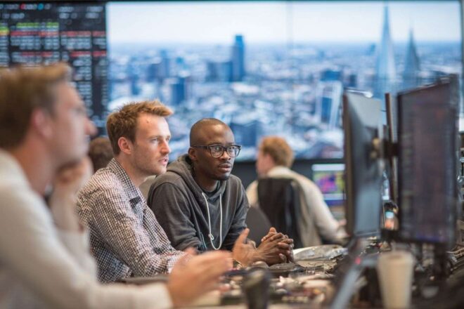 Investisseurs en technologie analysant des données avec une vue urbaine