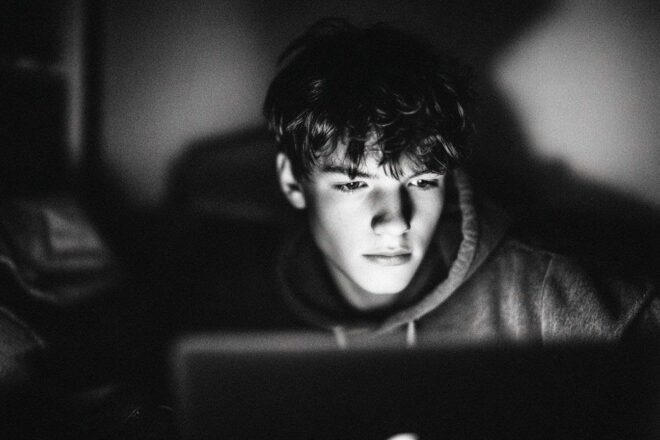 Adolescent éclairé par un écran d ordinateur portable