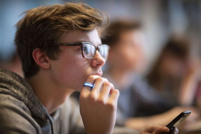 Adolescent en classe moderne avec bague connectée