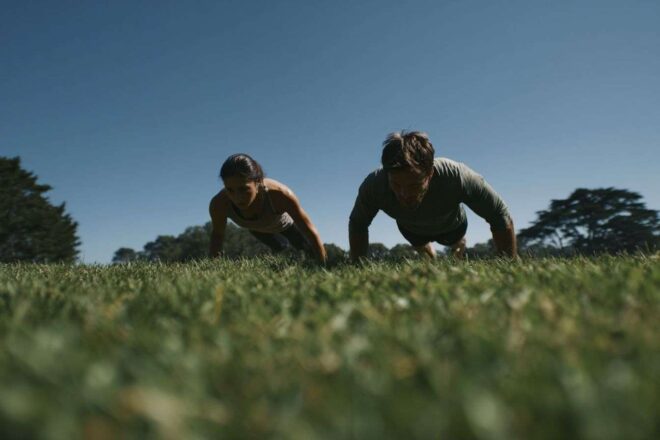 Deux coureurs faisant des exercices au sol