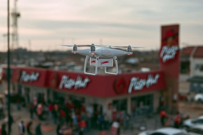 Livraison de pizza par drone devant un pizza hut animé