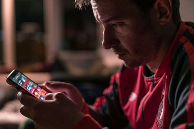 Supporter de football vérifiant son smartphone