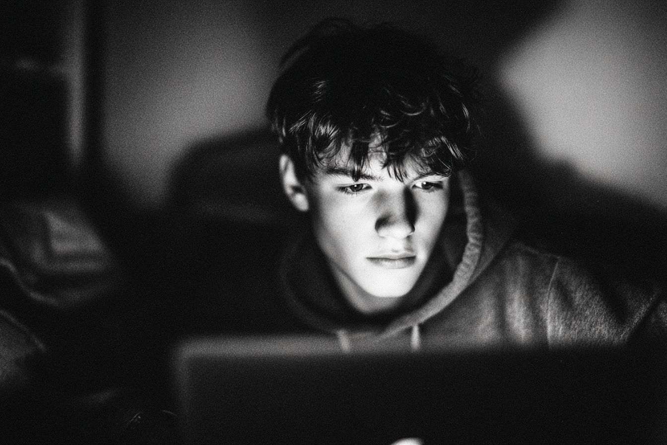 Adolescent éclairé par un écran d ordinateur portable